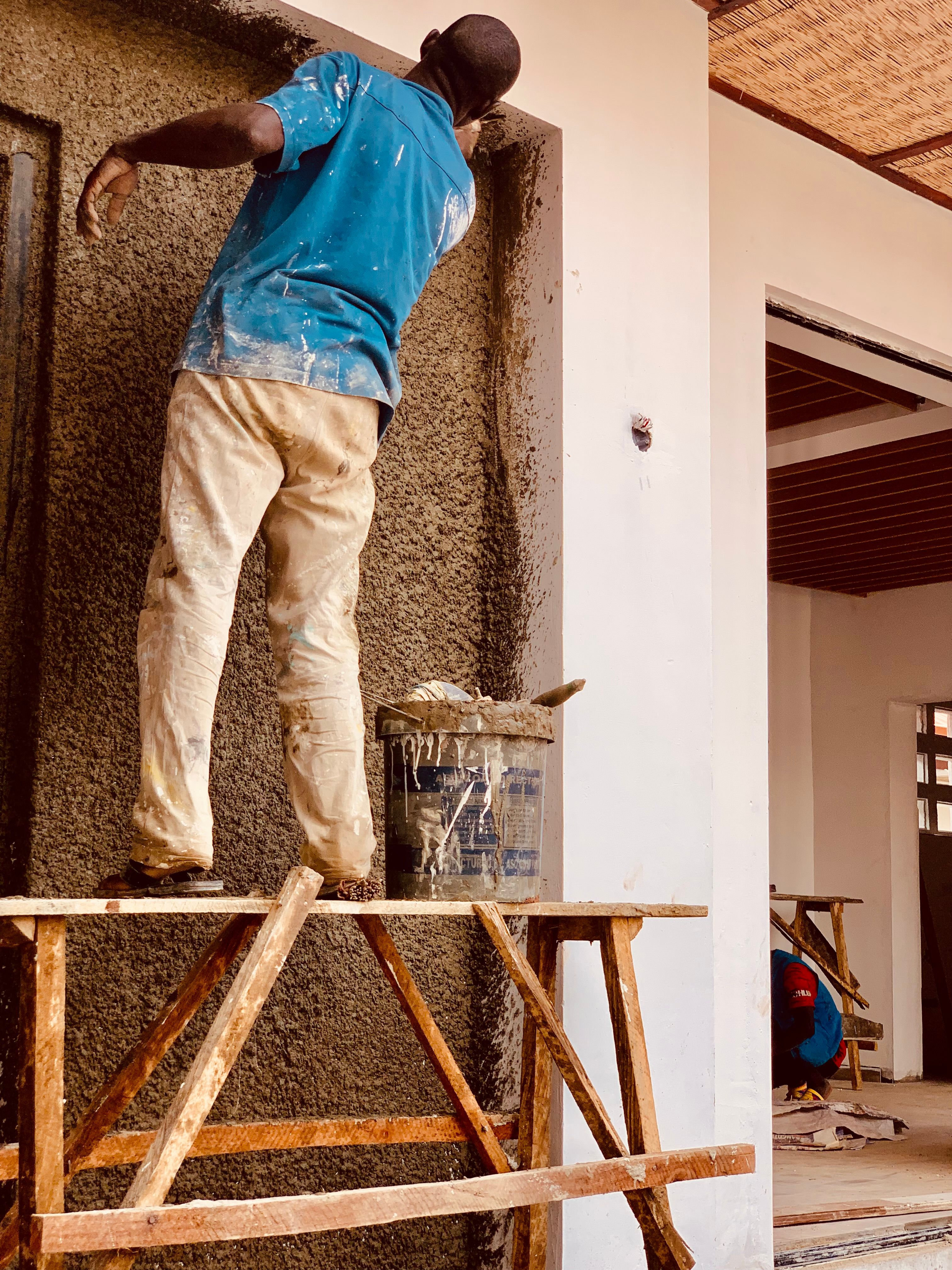 Stucco worker applying fresh dash to an exterior wall
